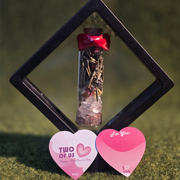 Relationship Booster Energy Bottle with pink quartz, rose petals, and candlelight