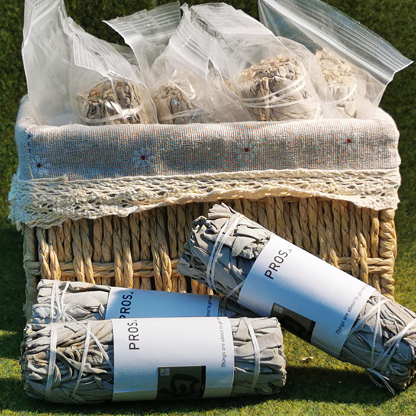 White sage for meditation placed on a wooden tray with candle and crystals